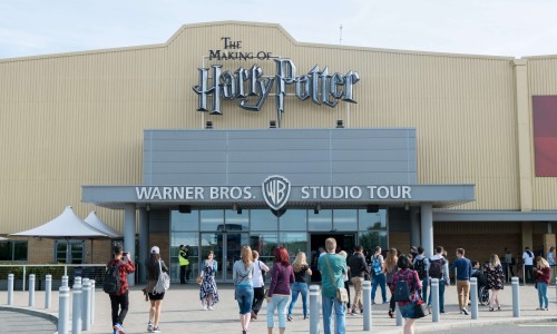 Tourists taking picture in front of the Warner Brothers Studio tour, The making of Harry Potter at Leavesden Studio in London.